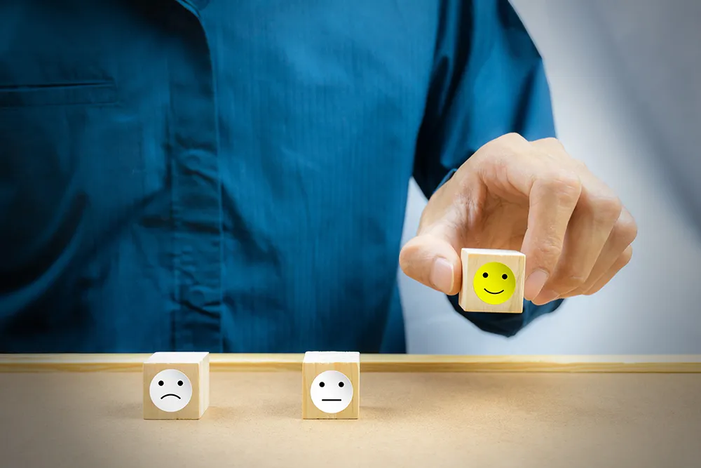 man holding a block with a smiley face on it