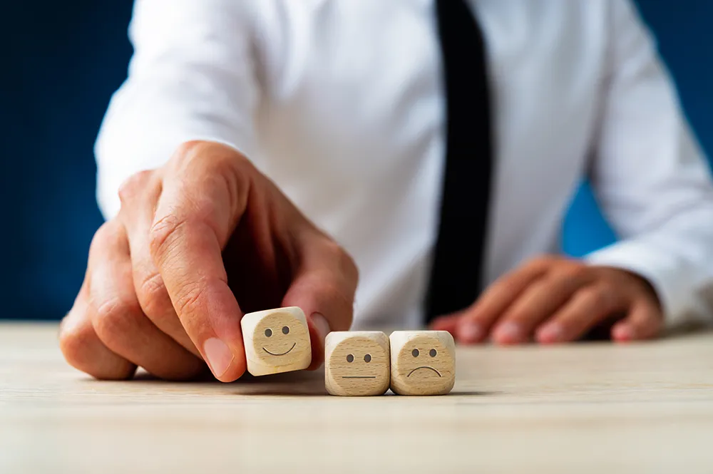 man holding a cube with a smiley face on it