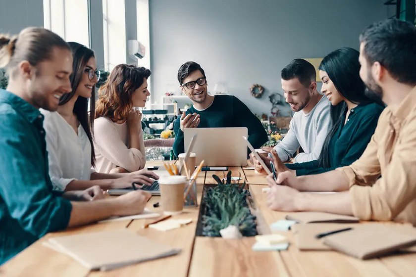 group of people talking with each other at a table