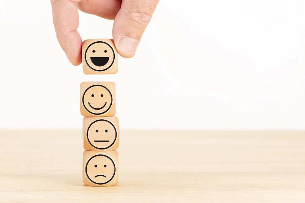 wooden cubes with different expressions stacked on top of each other