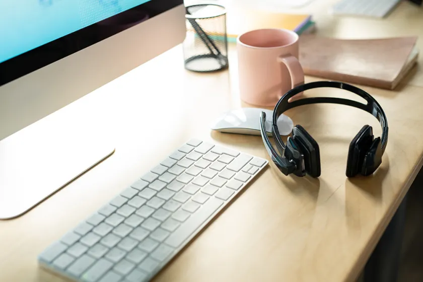 paid of headsets sitting on desk with Keyboard and mouse