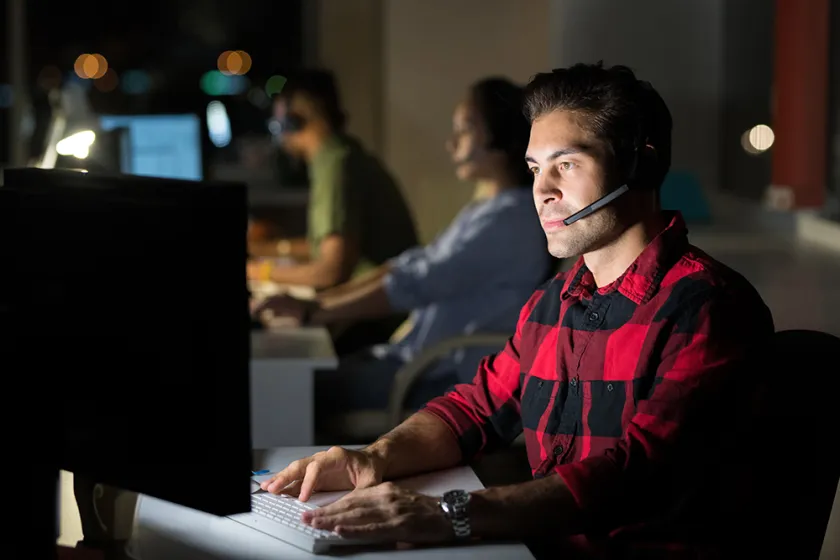 man with headset typing on keyboard